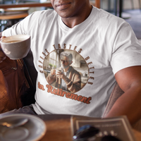 White tee featuring a senior man at his kitchen table enjoying a hot cup of coffee.