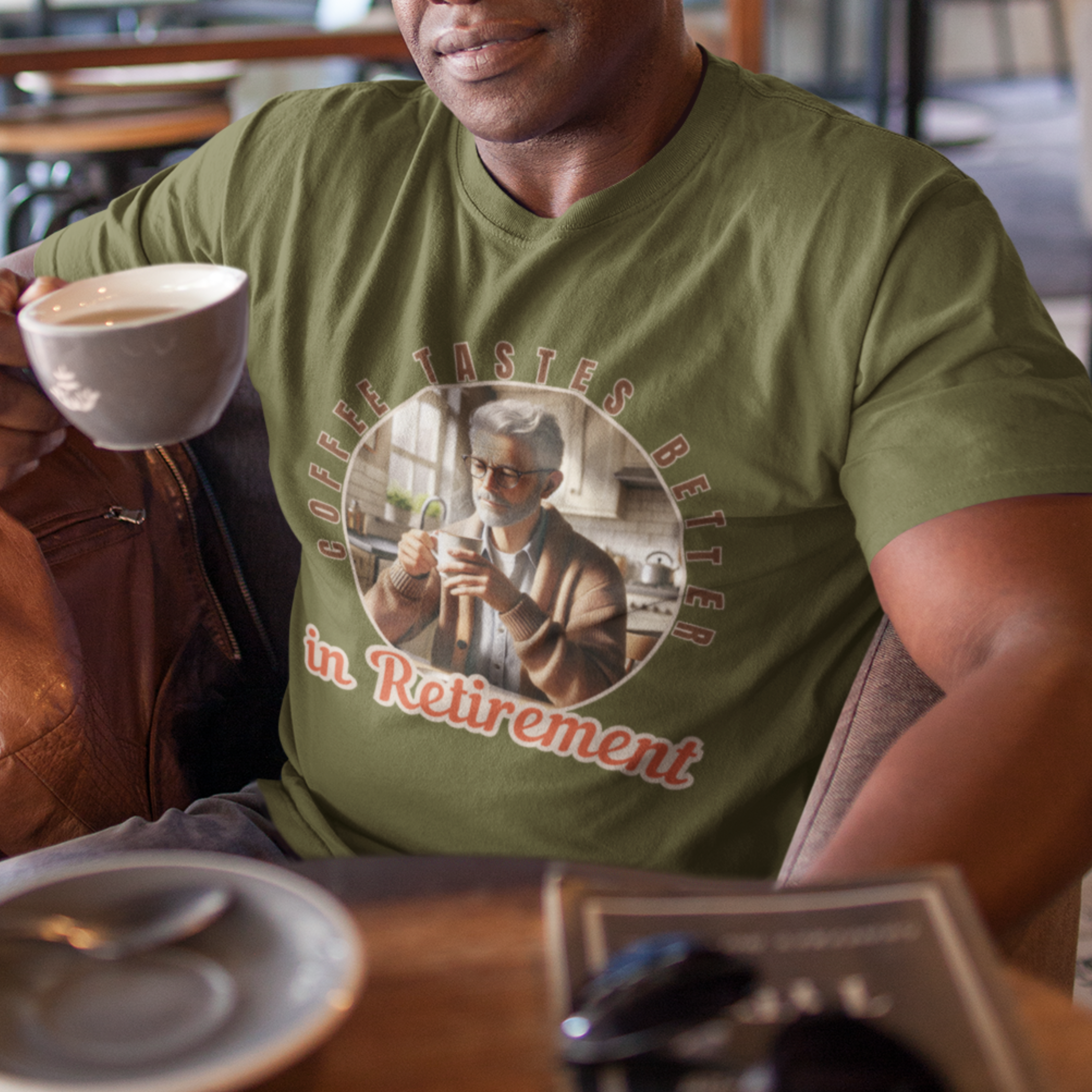 Military green tee featuring a senior man at his kitchen table enjoying a hot cup of coffee.