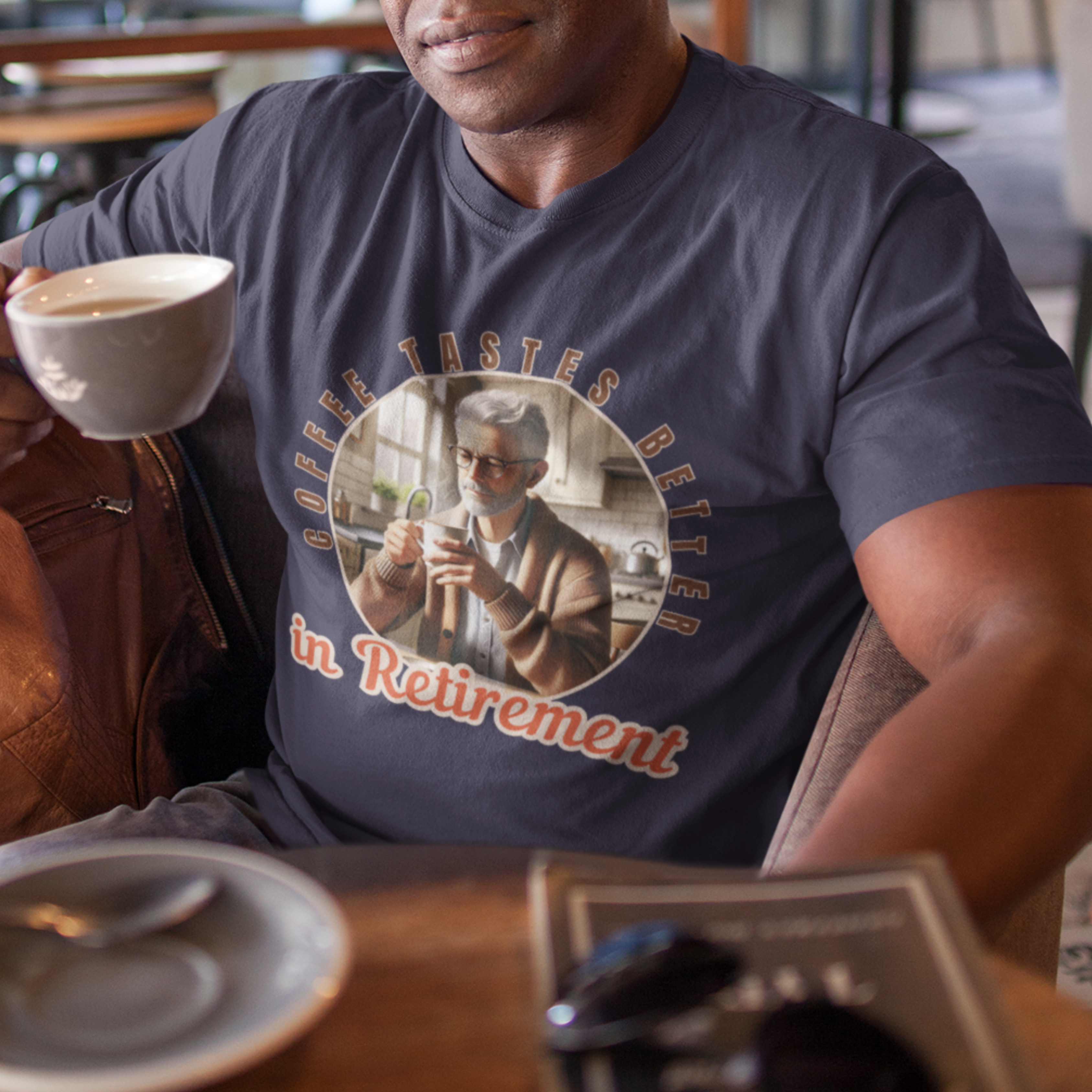 Navy blue tee featuring a senior man at his kitchen table enjoying a hot cup of coffee.