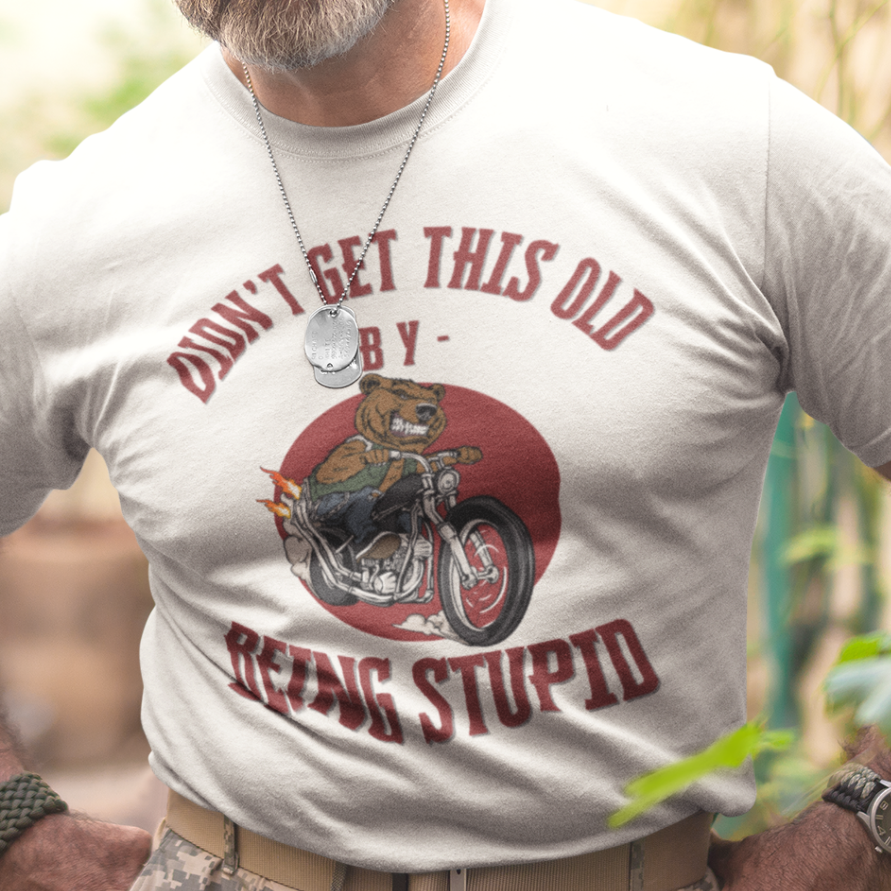 White t-shirt featuring a mean-looking cartoon grizzly on the back of a motorcycle blowing flames out the pipes.