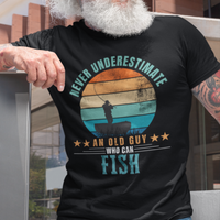 Black tee featuring silhouette of a fisherman in his boat cast against a stylish distressed striped sunset 