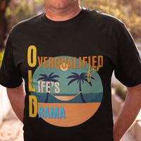 Black tee featuring a hammock between two palm trees on a secluded beach, reading "OLD: Overqualified for Life's Drama"