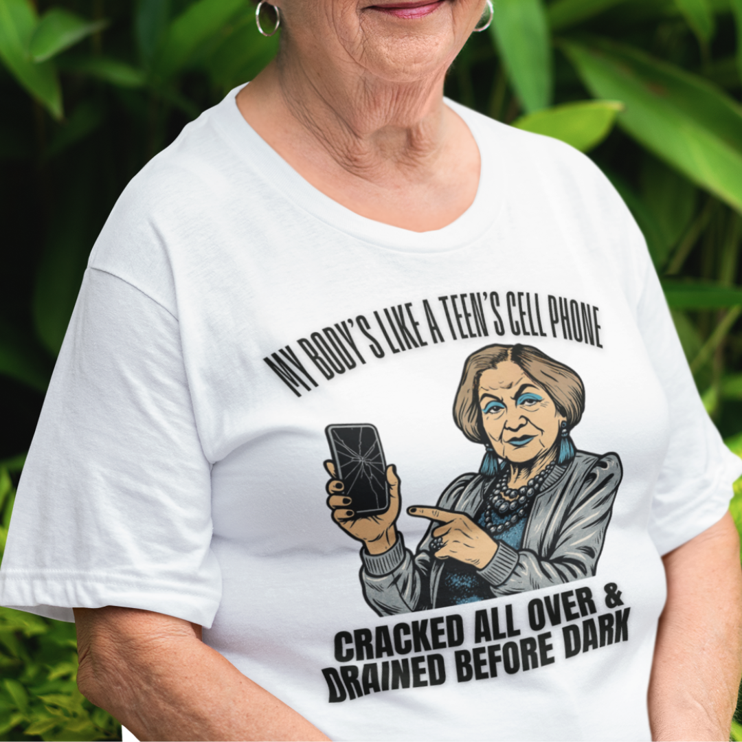 White t-shirt featuring a cartoon older woman pointing to a broken cell phone 